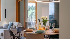 A dining area with a round table, chairs, and a vase of flowers. - Exclusive apartment right on the piste (Sonnenalpe Nassfeld)