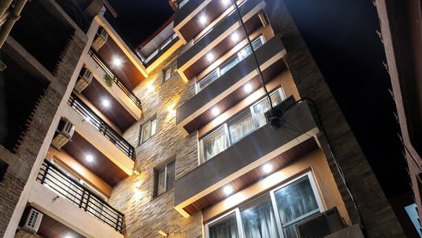 A multi-story residential building with balconies, a staircase, and a gated entrance. - Mandevilla Home (Lalitpur)
