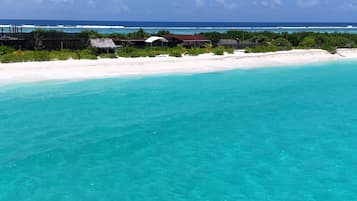 En privat strand, hvidt sand, gratis strandhytter, liggestole