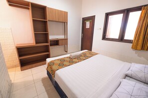 Une chambre à coucher avec un lit, une armoire, un bureau et une fenêtre avec des rideaux.