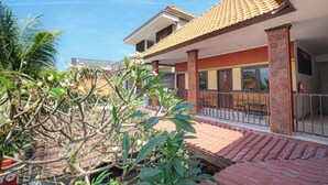 A residential building with a tiled roof, large windows, and a balcony with a railing. - Apartment Kak Okoh  (Munggu)