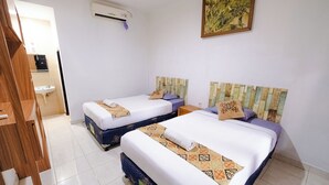 A hotel room with two beds, a sink, and an air conditioning unit. - Apartment Kak Okoh  (Munggu)