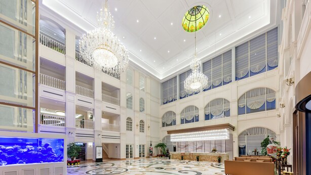 A spacious lobby with a high ceiling, chandeliers, a large aquarium, and a reception desk. - NARADA RESORT SHANGHAI  HOTEL Disney Store (Shanghai)