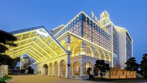 A hotel with a modern architectural design, featuring a prominent arched entrance and a large signboard. - NARADA RESORT SHANGHAI  HOTEL Disney Store (Shanghai)