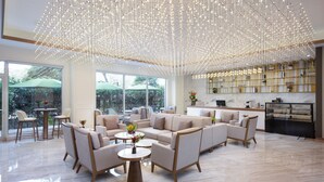 A spacious, well-lit lounge area with modern furniture, large windows, and a decorative light installation. - NARADA RESORT SHANGHAI  HOTEL Disney Store (Shanghai)
