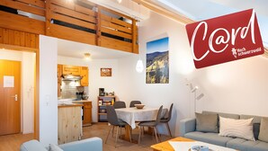 A modern interior with a dining area, kitchen, and a loft space.
