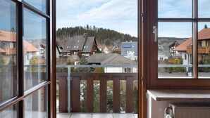 Ein Balkon mit Blick auf Häuser und einen Wald.
