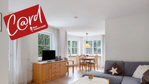 Un salon moderne avec un canapé, une table à manger et un téléviseur.