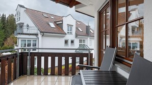 Ein Balkon mit Blick auf ein Wohngebäude, einem Holellentgel und einem Stuhl.