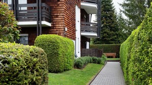 Un chemin menant à un bâtiment doté d’une façade en bois et d’un balcon.