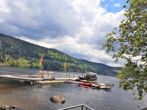 A lakeside dock with boats, a bridge, and a forested hill in the background. - Apartment 'Nr 1c' with Private Terrace and Wi-Fi (Titisee-Neustadt)