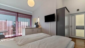 Een hotelkamer met een bed, een bureau, een televisie en een kledingkast.
