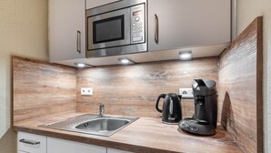 A kitchenette with a microwave, coffee maker, and sink. - Studio 'Rebstock' with Wi-Fi (Herbolzheim)