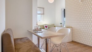 Uma sala de jantar moderna com uma mesa de madeira, cadeiras brancas e um banco.