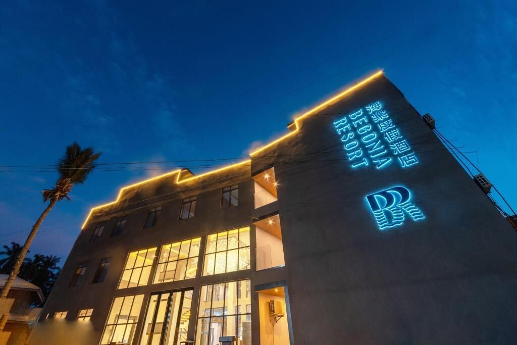 Un bâtiment sur lequel est apposée une grande enseigne lumineuse indiquant : « BÉGONIA RESORT ».