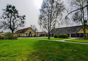 A courtyard with a lawn, pathways, and buildings with a traditional architectural style. - Apartment 'Lütten Ankerplatz' with Private Terrace and Wi-Fi (Eggesin)