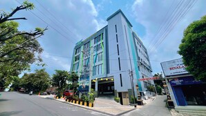 A modern hotel with a prominent entrance, multiple floors, and a visible sign for a nearby restaurant. - Front One Boutique Adria Boyolali (Boyolali)