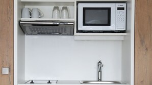 A compact kitchen with a Bosch microwave, a built-in oven, and a sink. - Apartment 'Nr 2' with Mountain View, Shared Terrace and Wi-Fi (Vaihingen)