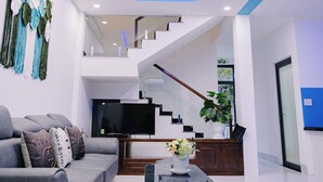 Un salon moderne avec un canapé, une table basse et un téléviseur.