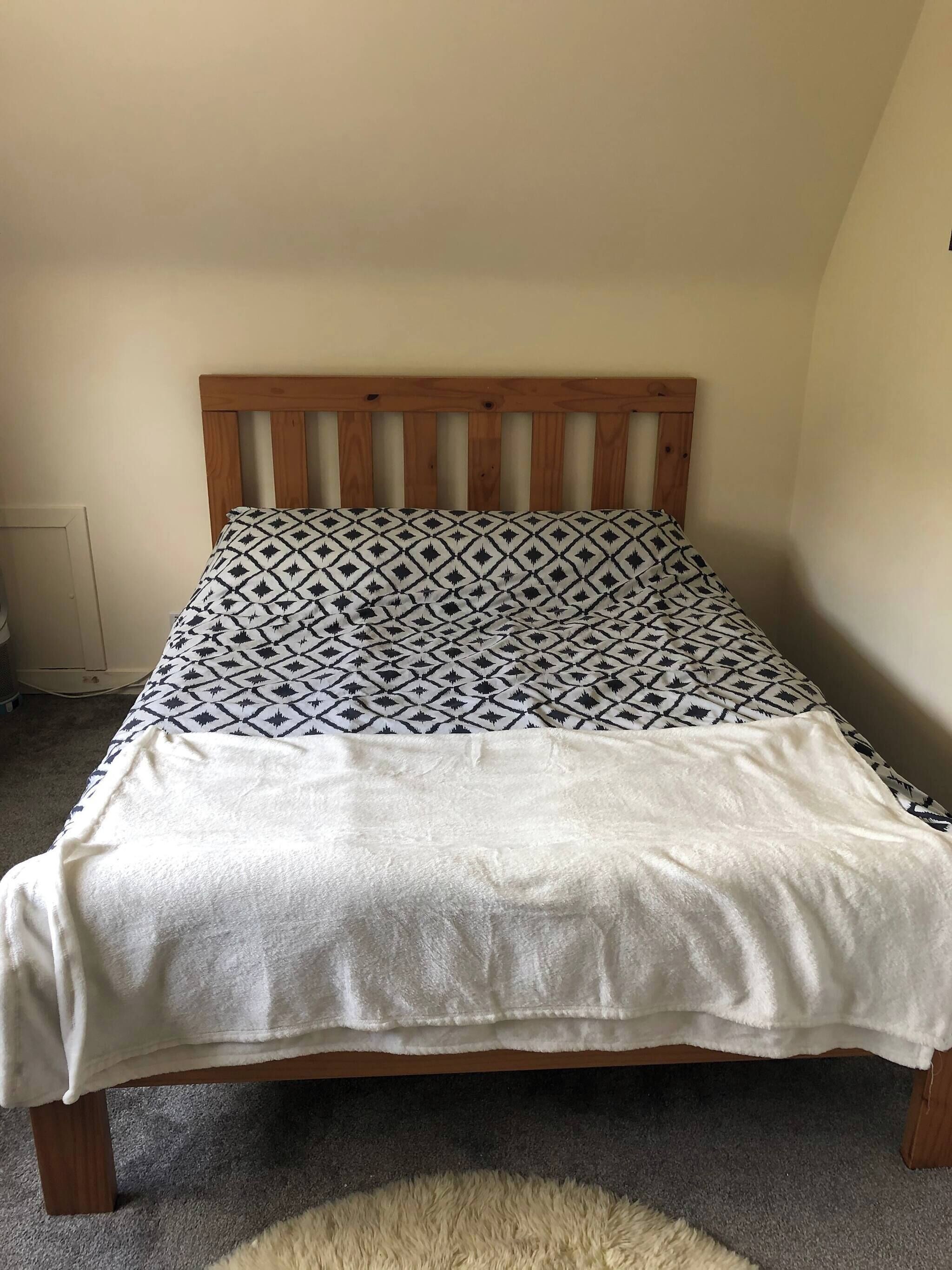 A bed with a patterned headboard and a white blanket.