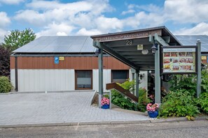 A building with a sign reading 'Herzlich Willkommen 29' and a covered entrance. - Apartment '4 Hase, 49qm' with Private Terrace and Wi-Fi (Schönwald im Schwarzwald)