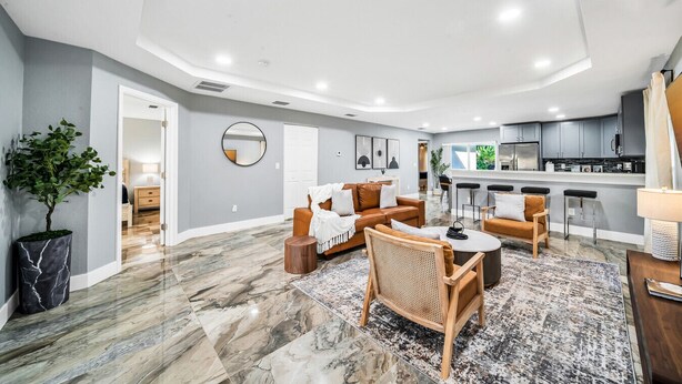 Un espacio habitable amplio con una cocina moderna, una zona de comedor y un área de estar con una mesa de centro y sillas.