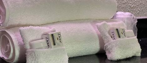 Een haardroger, handdoeken, zeep, toiletpapier