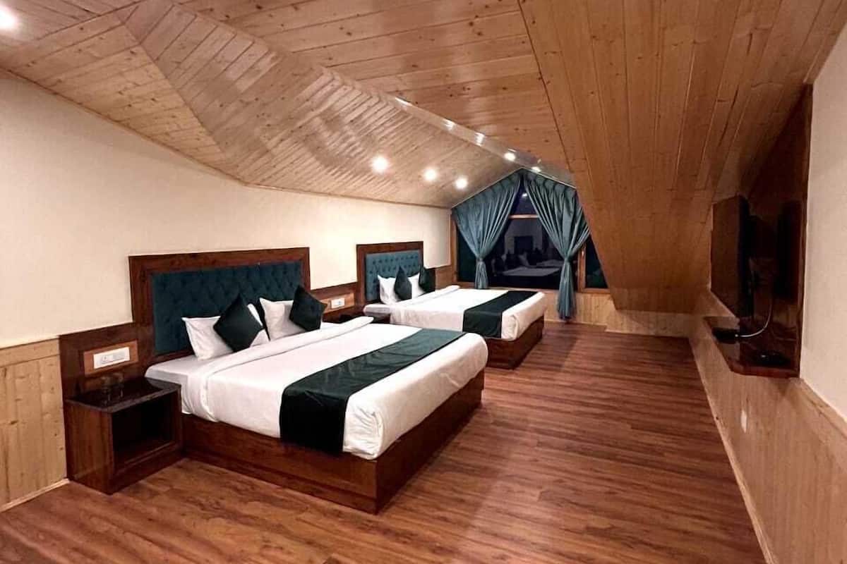 Una stanza con tre letti, pavimento in legno e soffitto a falde.