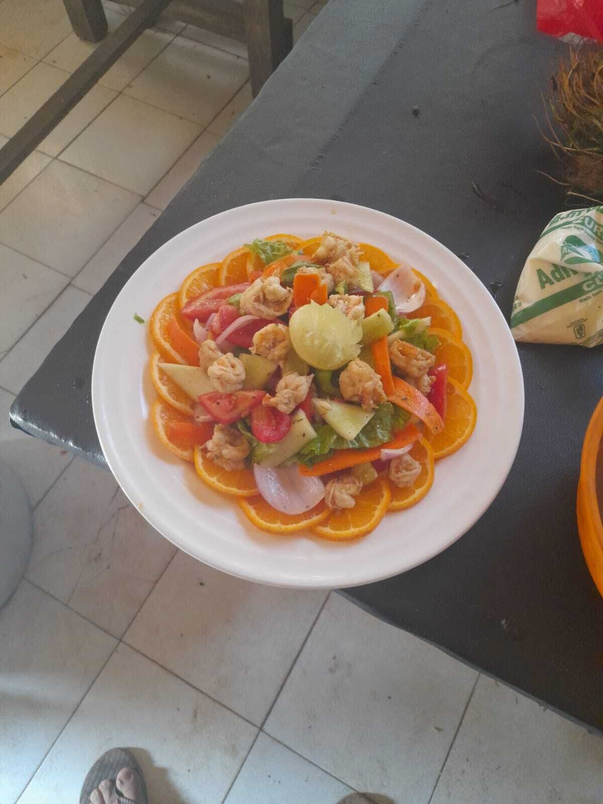 Un plato de comida con varios vegetales y carne, sobre una mesa.