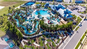 An aerial view of a resort with multiple swimming pools, palm trees, and a parking area. - On-Site Waterpark, Pool & Sleeps 26 | Resort Home – Flamingo Grove by AvantStay (Davenport)