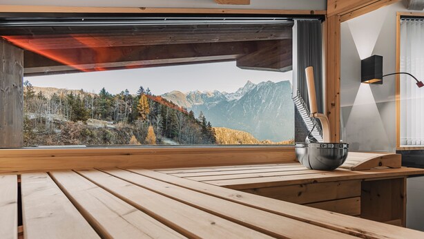 A wooden table with a view of a mountainous landscape through a window. - See the Holiday Home with Lake View, Private Terrace and Wi-Fi (Oetz)