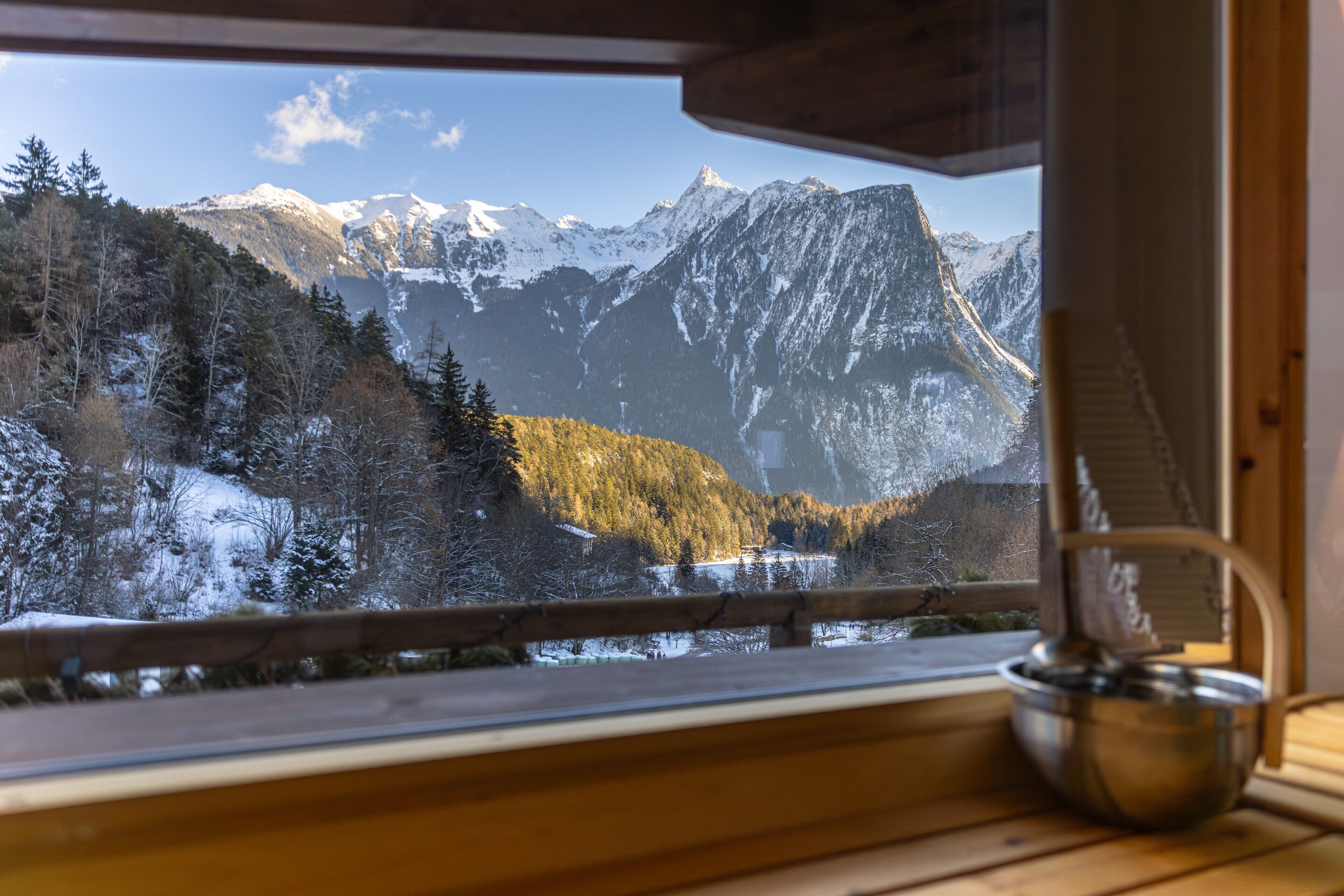 Une pièce avec une fenêtre donnant sur des montagnes enneigées et un intérieur en bois.