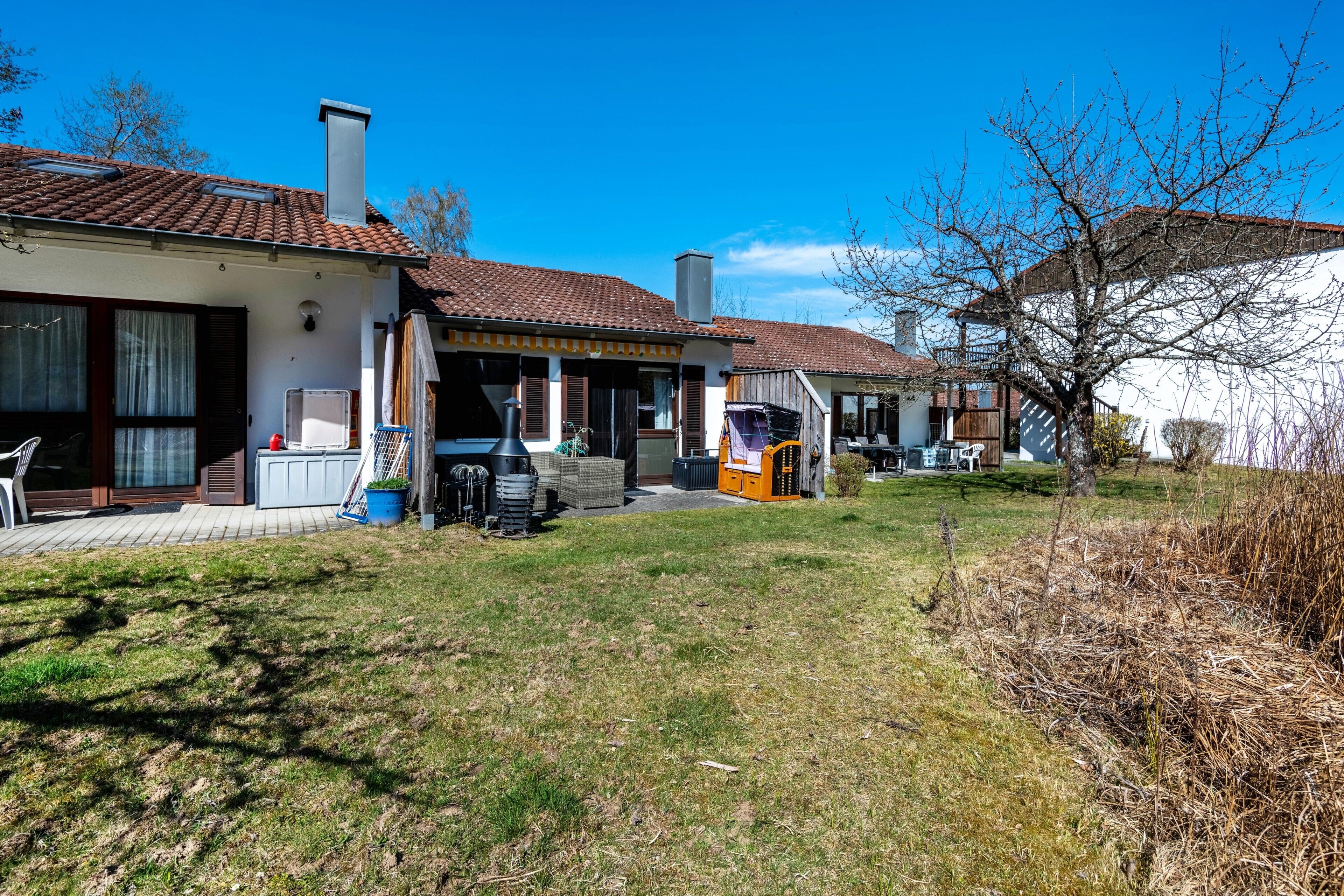 A residential property with a patio, outdoor seating, and a chimney.