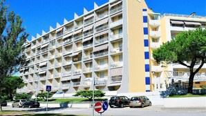 A multi-story hotel with balconies, a pedestrian crossing sign, and a no-entry sign.