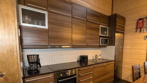 Eine moderne Küche mit Holzausstattung, Edelstahlgeräten, einer Mikrowelle und einer Kaffeemaschine.