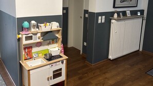 A room with a wooden play kitchen, a radiator, and a framed artwork on the wall. - Room 'Haus Erika 1' with Shared Terrace and Wi-Fi (Lingen (Ems))