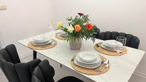 Et spisebord dækket med tallerkener, glas og en dekoration i midten.