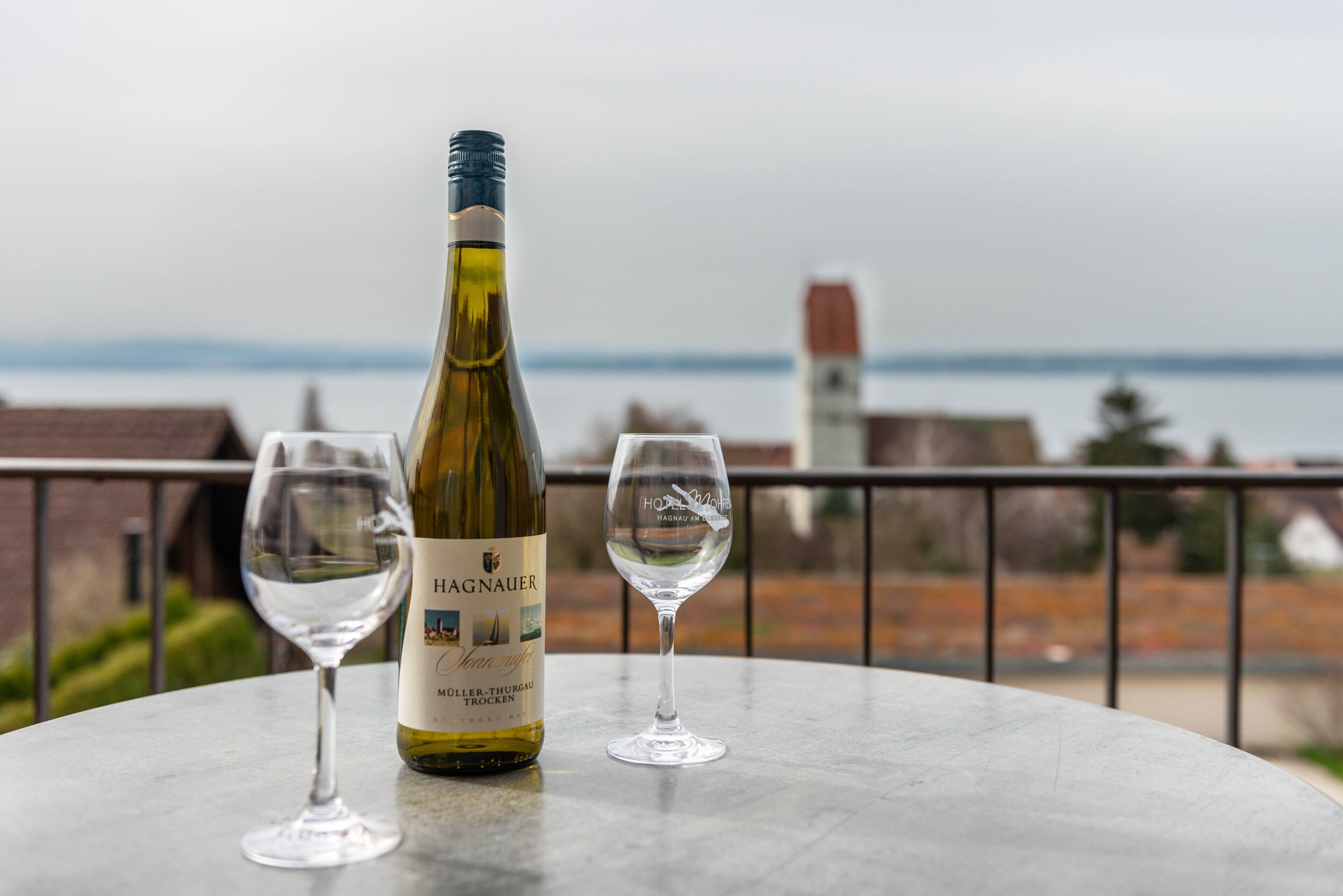 Una bottiglia di vino e due bicchieri su un tavolo con vista sulla città.