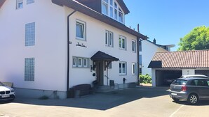 A two-story building with a sign reading 'Lodge Carst.' - Double Room with Lake View, Balcony and Wi-Fi (Hagnau am Bodensee)