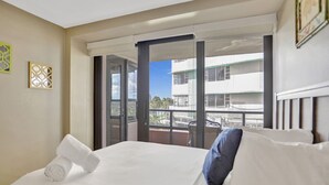 Une chambre d’hôtel avec un lit, une vue sur l’extérieur et un balcon.