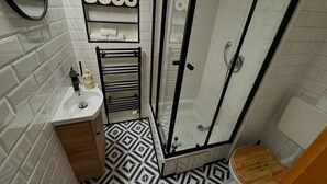 A bathroom with a shower, toilet, sink, and a shelf with toilet paper. - Pfullingen 1 – Accommodation for Workers, Worker House Single Rooms, Wi-Fi (Pfullingen)