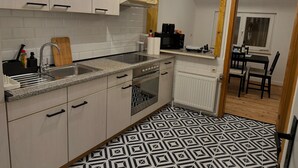 A kitchen with white cabinets, a granite countertop, a sink, a stove, and a microwave. - Pfullingen 1 – Accommodation for Workers, Worker House Single Rooms, Wi-Fi (Pfullingen)
