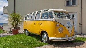 A yellow and white vintage VW camper van parked in front of a building with a sign that reads 'HOTEL'. - Comfort Room with Wi-Fi (Hagnau am Bodensee)