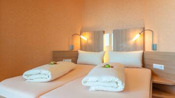 Ein Hotelzimmer mit einem Doppelbett, zwei Nachttischen und Wandlampen.