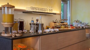 A buffet setup with various food and drink dispensers, glassware, and baskets. - Comfort Room with Side Lake View, Balcony and Wi-Fi (Hagnau am Bodensee)