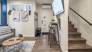 A modern living room with a sofa, coffee table, and artwork on the walls. - Rooftop Vibes!  Greenlake UW Near Down Town (Seattle)