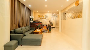 A modern living room with a sectional sofa, a coffee table, and a decorative plant arrangement. - An's House  (Xuan Huong - Da Lat)