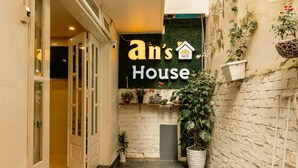 A narrow hallway with a sign reading "an's House 1413" and potted plants along the walls. - An's House  (Xuan Huong - Da Lat)