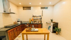 A compact kitchen with wooden cabinets, a microwave, a coffee maker, and a refrigerator. - An's House  (Xuan Huong - Da Lat)
