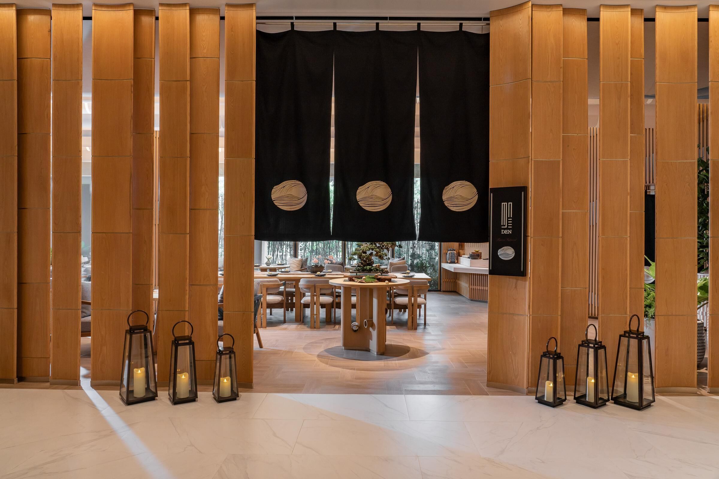 A modern interior with a wooden partition, a dining area, and lanterns.